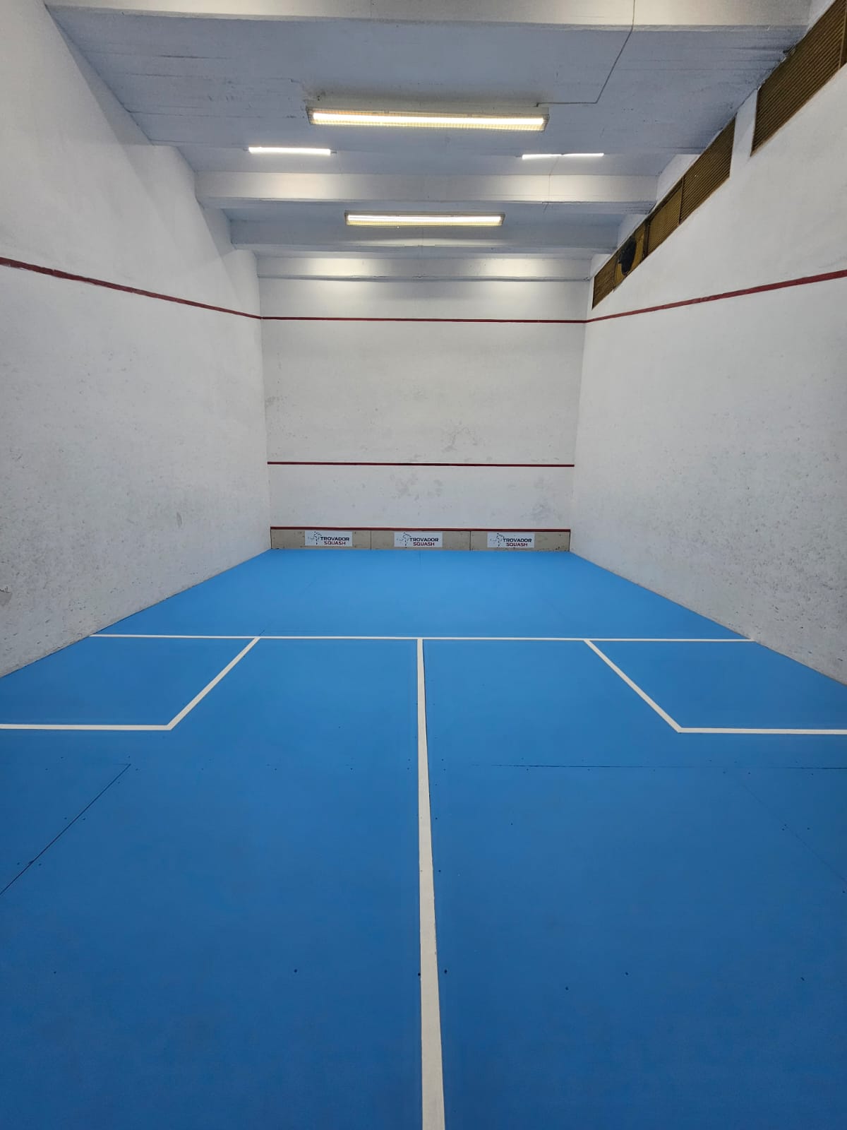 Cancha de squash con piso azul en Trovador Squash, Vicente López